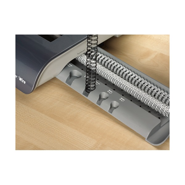 Close view of a black wire comb hung on the Quasar comb support next to the closing jaws on a wooden desk