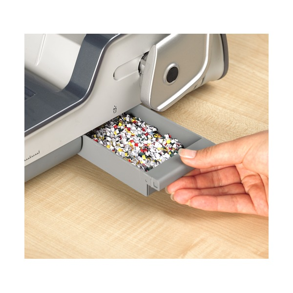 Hand drawing out the Quasar 130 waste tray full of multicoloured paper clippings from the side of the machine