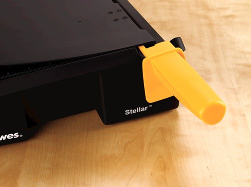 Close-up of a Fellowes Stellar guillotine on a desk with the guard folded down and the yellow handle locked