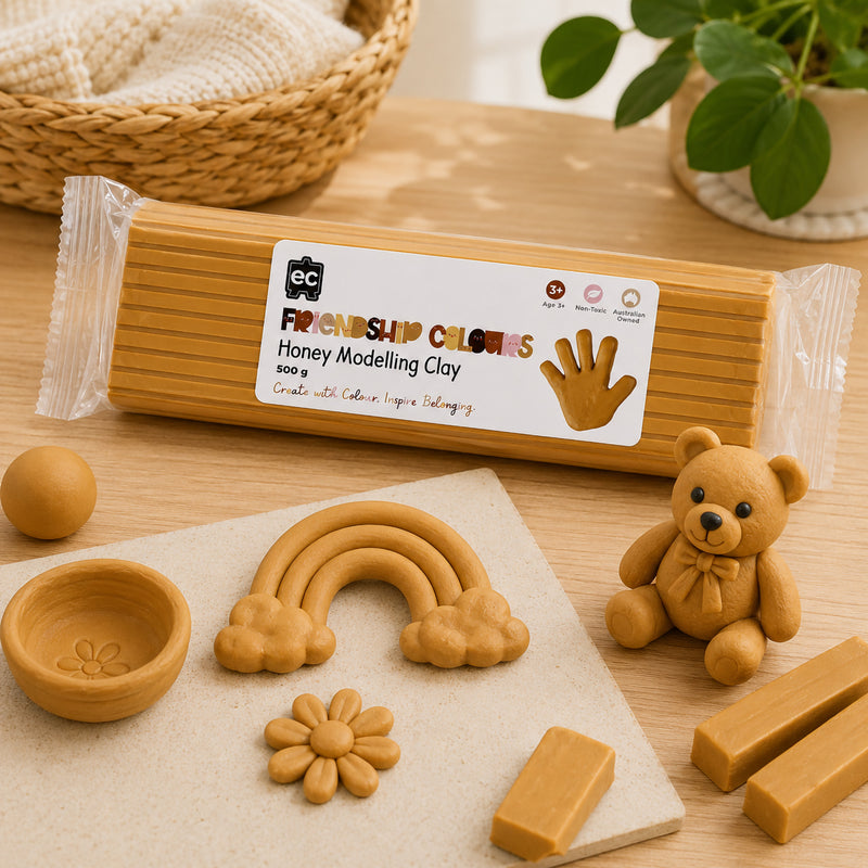 Friendship Colours Honey Modelling Clay 500g displayed with finished clay creations including a teddy bear, rainbow, flower and decorative bowl. The warm honey tone demonstrates how the clay can be used for character modelling, storytelling and creative educational play.