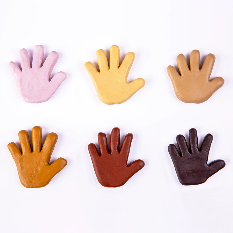 Six hand shaped clay samples displayed in varying skin tone colours against a white background. The mahogany shade appears as part of the Friendship Colours collection, promoting inclusion, representation and diversity through creative expression.