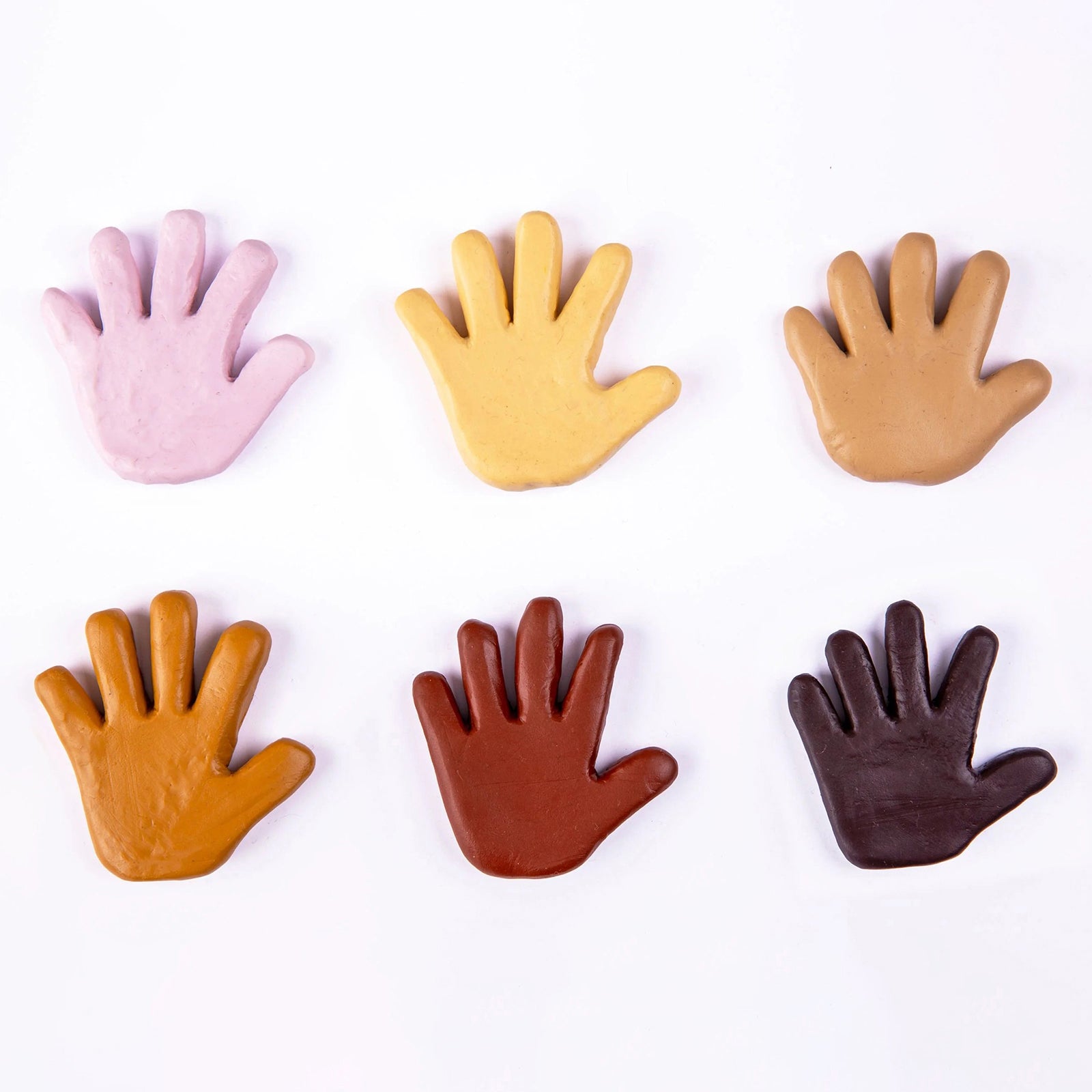 Six hand shaped clay samples displayed in different Friendship Colours skin tone shades. The olive colour is shown alongside complementary tones, demonstrating the inclusive range designed to promote diversity, representation and multicultural learning.