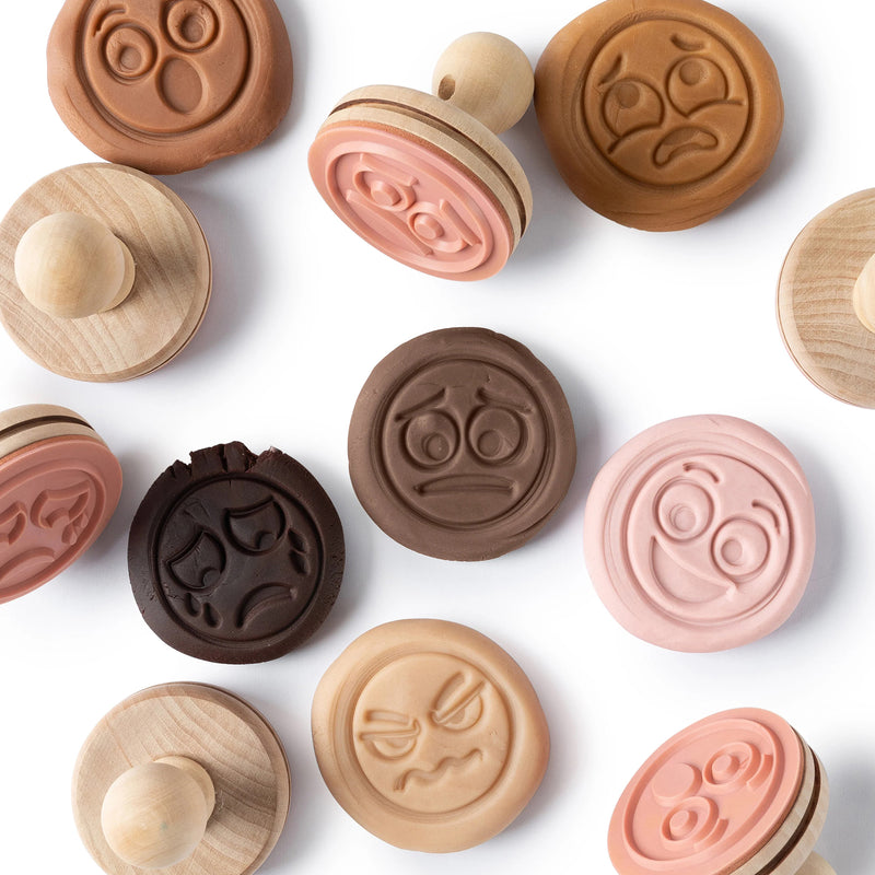 Detailed view of emotion stamp impressions pressed into the different dough colours. The image highlights social emotional learning opportunities through facial expression recognition, storytelling and creative play activities.