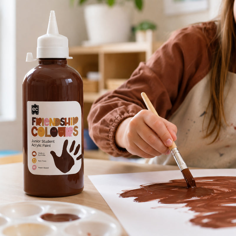 Friendship Colours Espresso Acrylic Paint 500ml featured alongside a young artist actively painting. The deep skin tone inspired colour demonstrates smooth coverage and is ideal for self portraits, multicultural artwork and educational creative projects.