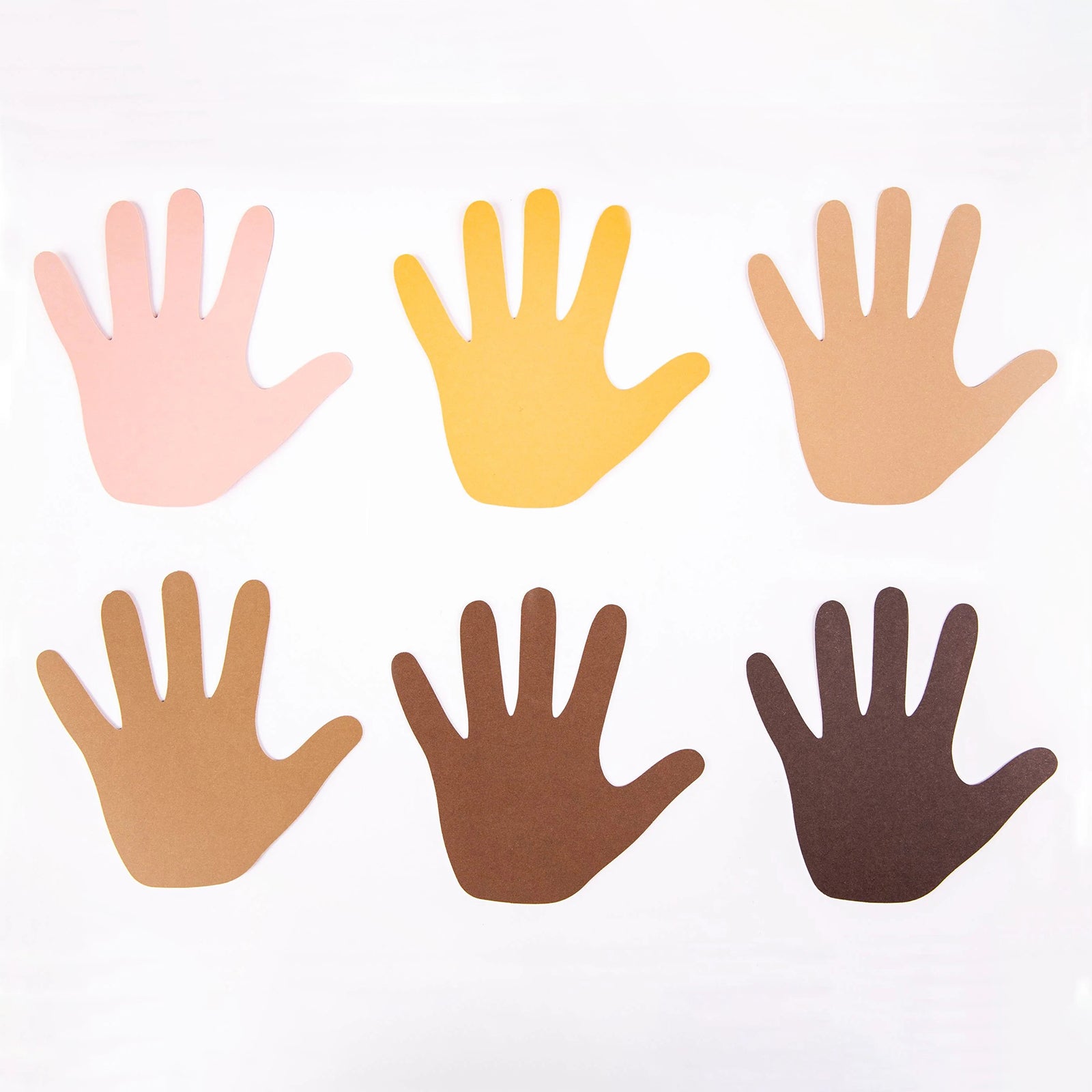 Close up display of six paper hand shapes presented in a range of realistic skin tone colours from light to dark. The pre cut shapes provide an excellent resource for diversity projects, friendship activities and collaborative classroom displays.