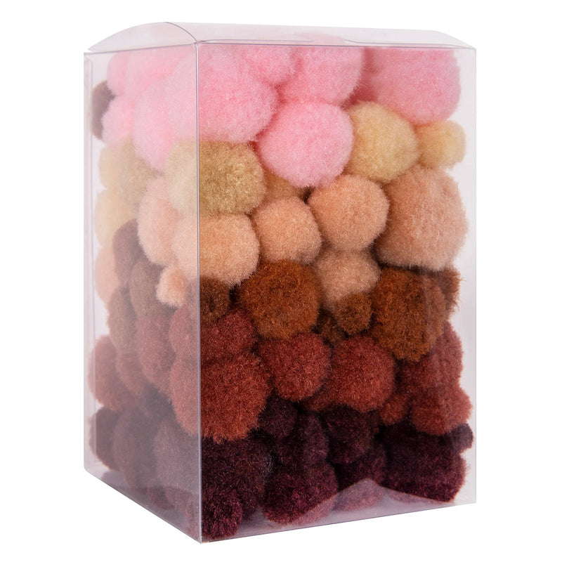 Clear container filled with Friendship Colours Pom Poms arranged by skin tone inspired shades from light pinks through rich browns. The image showcases the broad colour range and assorted sizes included within the 150 piece set.