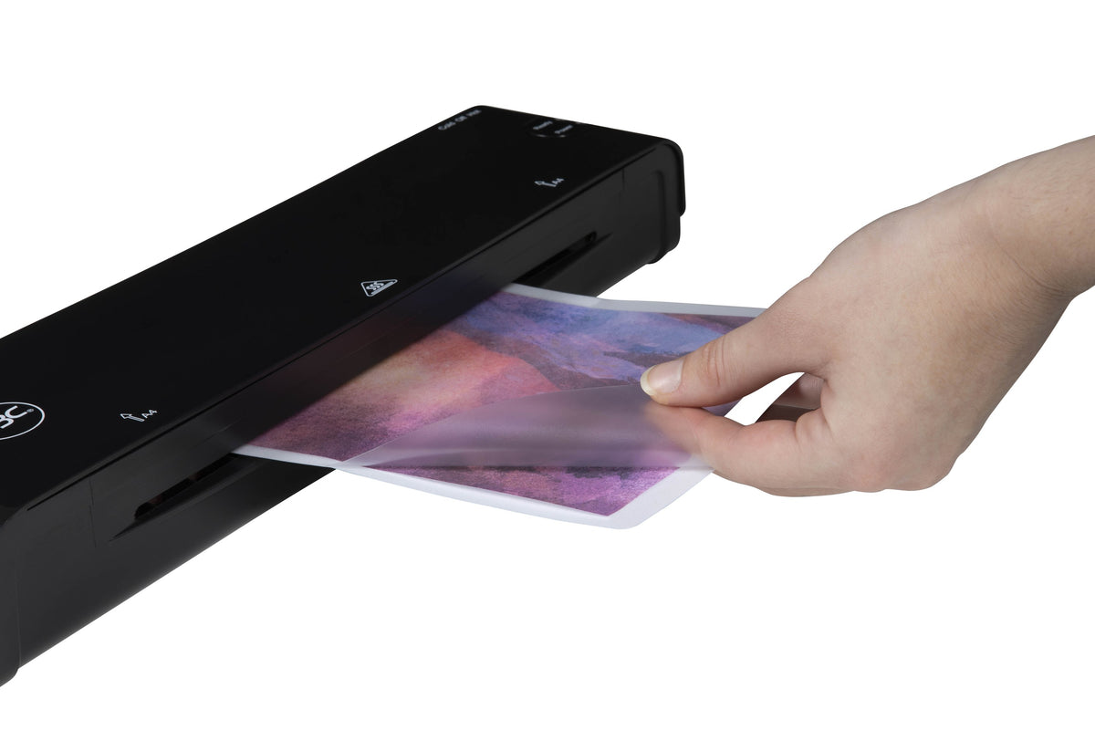 Hand feeding a GBC A5 adhesive back laminating pouch holding a purple and pink print into the slot of a black GBC pouch laminator