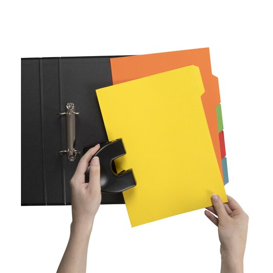 Hands punching a yellow GBC tab divider with a black desk punch beside an open black lever arch file holding an orange divider