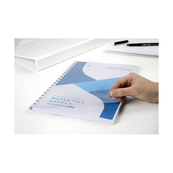 Hand lifting a clear front cover on a brochure bound with a white plastic comb, the printed title page underneath