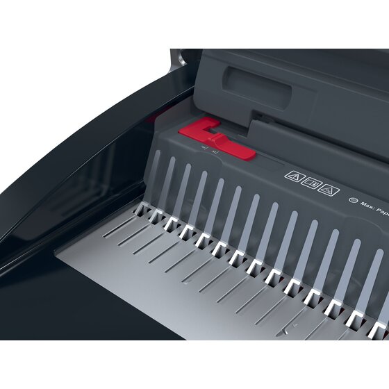 Close view of the GBC CombBind CB25 punch area with the comb pins, a red margin slider and printed safety symbols