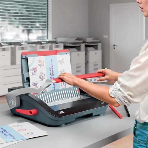 Person pressing the handle of a GBC CombBind CB25 in an office while a printed document sits on the comb opener