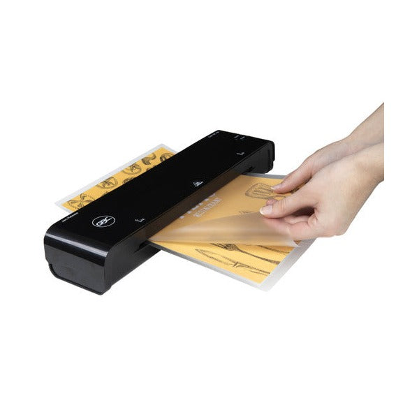 Hand drawing a laminated menu page out of the front of a black GBC pouch laminator on a white background