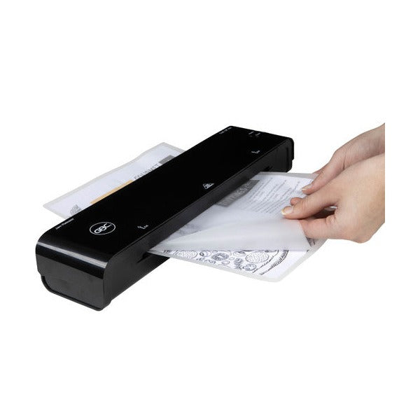 Hand pulling a laminated A4 page from the output side of a black GBC pouch laminator on a plain white background