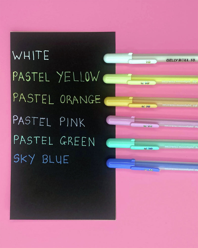 Close view of a black card labelled White to Sky Blue with six pastel pens on pink