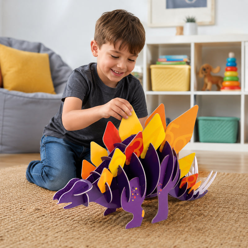 Child assembling the Giant 3D Puzzle Stomping Stegosaurus on a carpeted floor, carefully placing colourful numbered dinosaur plates onto the purple dinosaur body while enjoying hands on educational play in a bright family room.