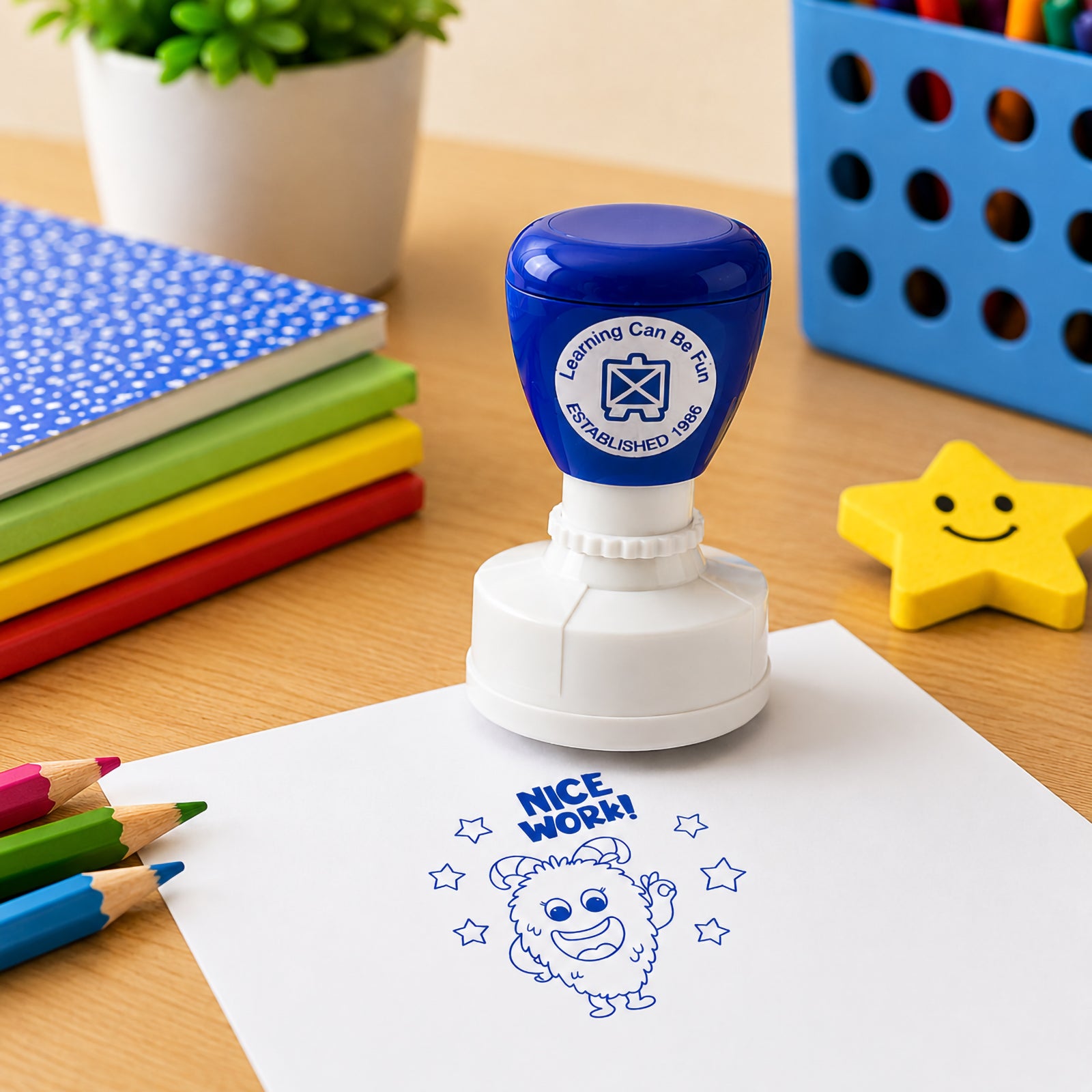 Learning Can Be Fun Nice Work reward stamp displayed on a worksheet beside colourful stationery and a smiling star eraser. The bold blue impression highlights the positive message and playful character designed to encourage students and build confidence.
