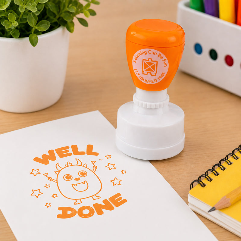 Learning Can Be Fun Well Done reward stamp positioned on a worksheet with classroom stationery and educational resources nearby. The bold orange stamped design highlights the motivational message and playful character used to encourage students and reward effort.