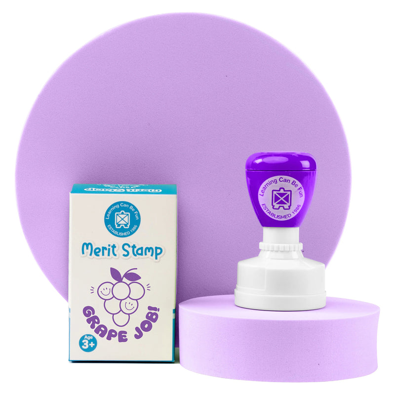 Retail packaging and Grape Job Merit Stamp presented together on a display platform. The packaging highlights the fun grape design and educational purpose, making it ideal for teachers and learning environments.