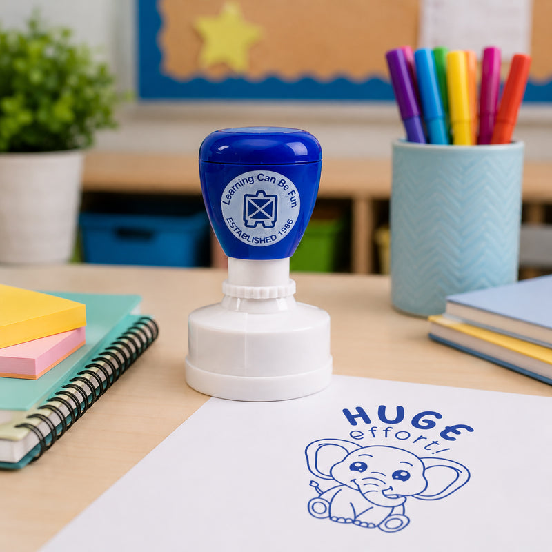 Close up classroom scene featuring the Huge Effort reward stamp and a bold blue elephant impression on paper. The design highlights determination and achievement while creating memorable student recognition.