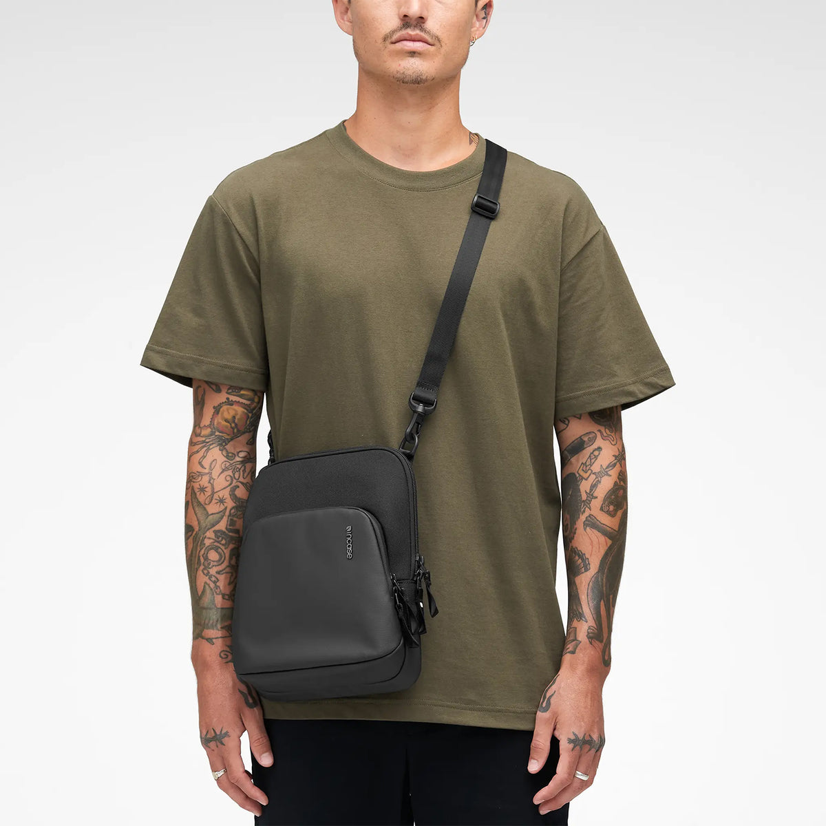 Studio portrait showing the Incase A.R.C. Crossbody Bag worn crossbody with casual clothing. The image focuses on the streamlined silhouette, premium materials and balanced proportions, demonstrating its versatile unisex design suitable for work, travel and everyday city life.