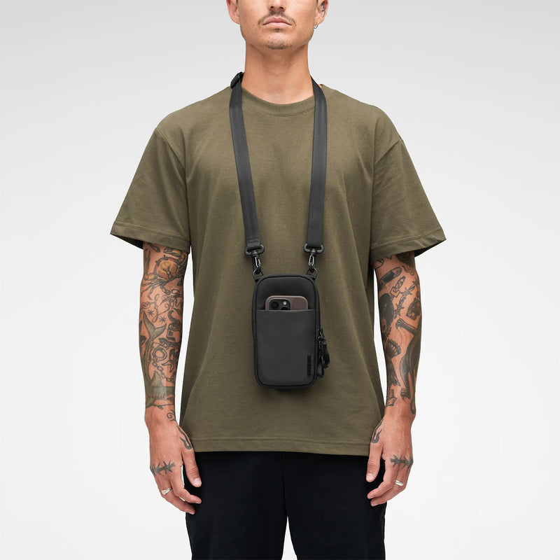 Studio lifestyle image featuring the bag worn around the neck with the adjustable strap extended. The compact size and minimalist design are clearly demonstrated for everyday urban use.
