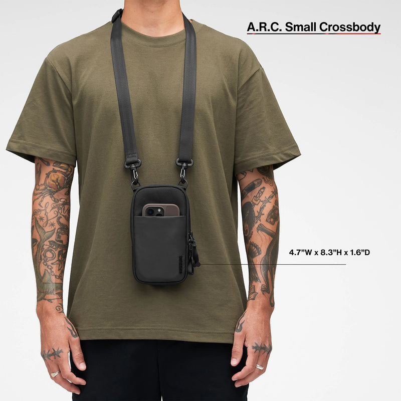 Full body front view of the Incase A.R.C. Small Crossbody Bag worn with casual clothing. The image includes overall dimensions and shows how the bag hangs comfortably from the adjustable shoulder strap.