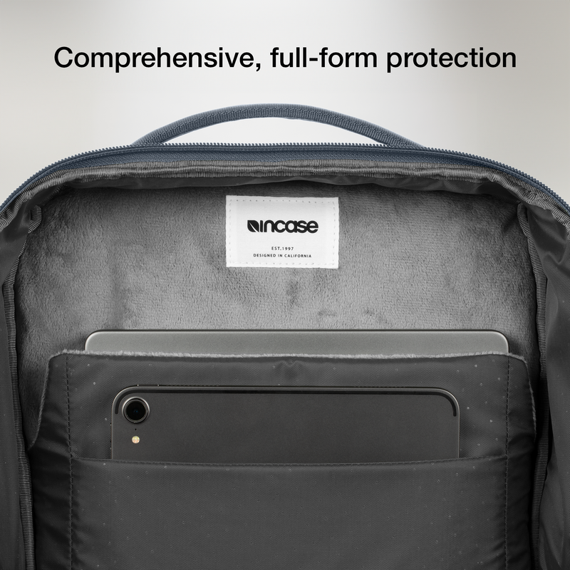 Open laptop compartment of the navy Incase A.R.C. Daypack, showing the soft grey lining and a tablet in the front slip pocket