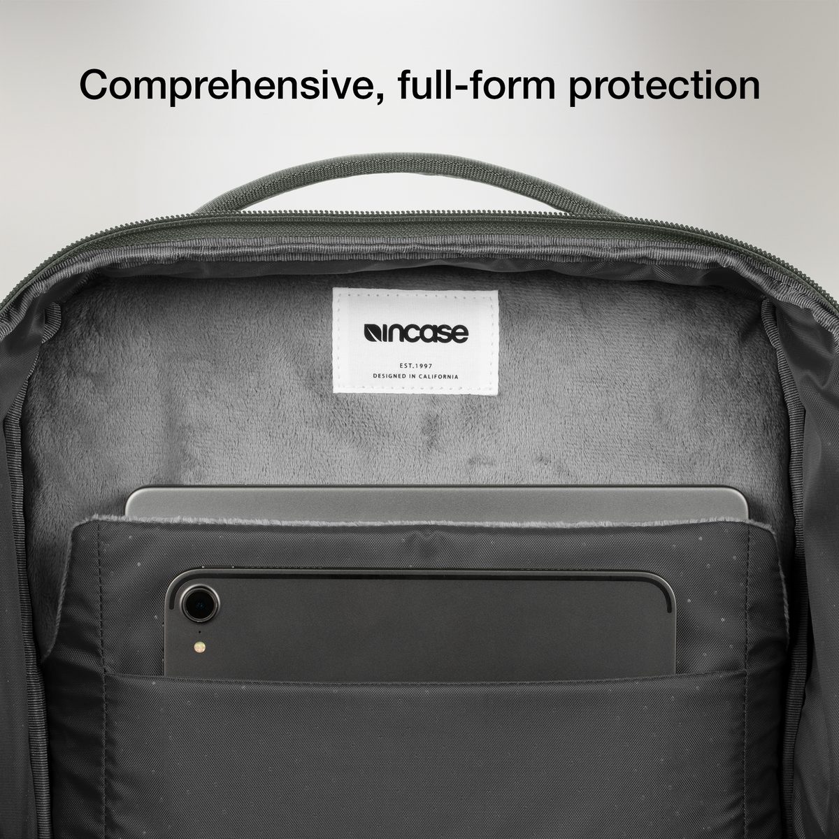Open laptop compartment of the Smoked Ivy Incase A.R.C. Daypack, showing the soft grey lining and a tablet in the front slip pocket