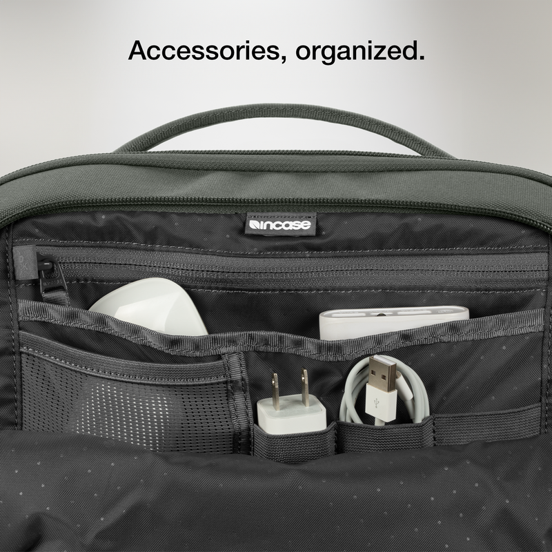 Close-up of the open organiser pocket of the Smoked Ivy Incase A.R.C. Daypack with a charger and cables, with Incase's caption on organised accessories