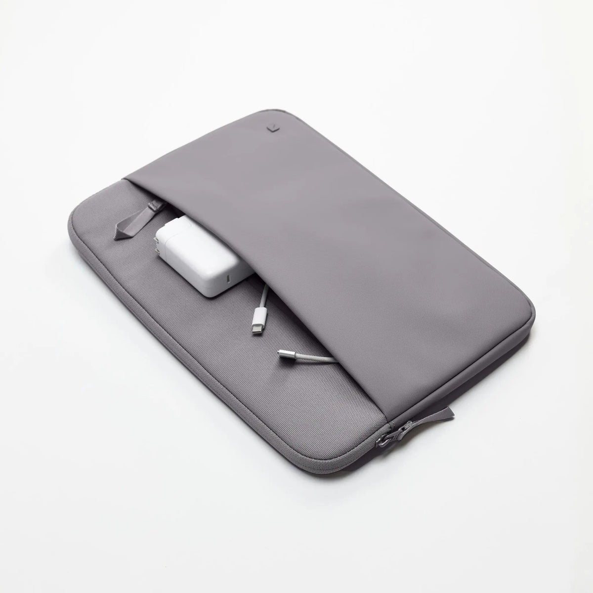 Gray A.R.C. 14-inch sleeve lying flat with a charger and cable tucked into the external zip pocket