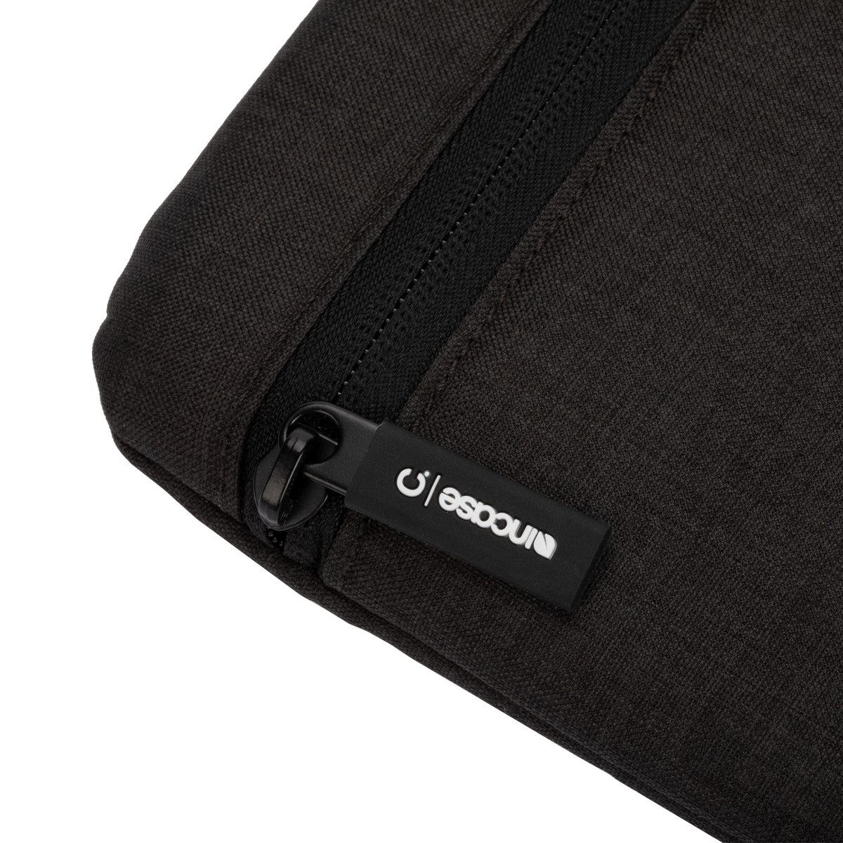 Incase Carry Zip Sleeve for 13-inch laptops in black, close-up of the zip pull with its Incase tab on the very dark heathered fabric