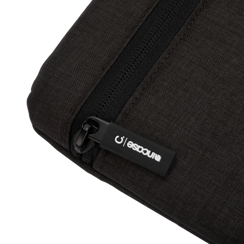 Incase Carry Zip Sleeve for 13-inch laptops in black, close-up of the zip pull with its Incase tab on the very dark heathered fabric