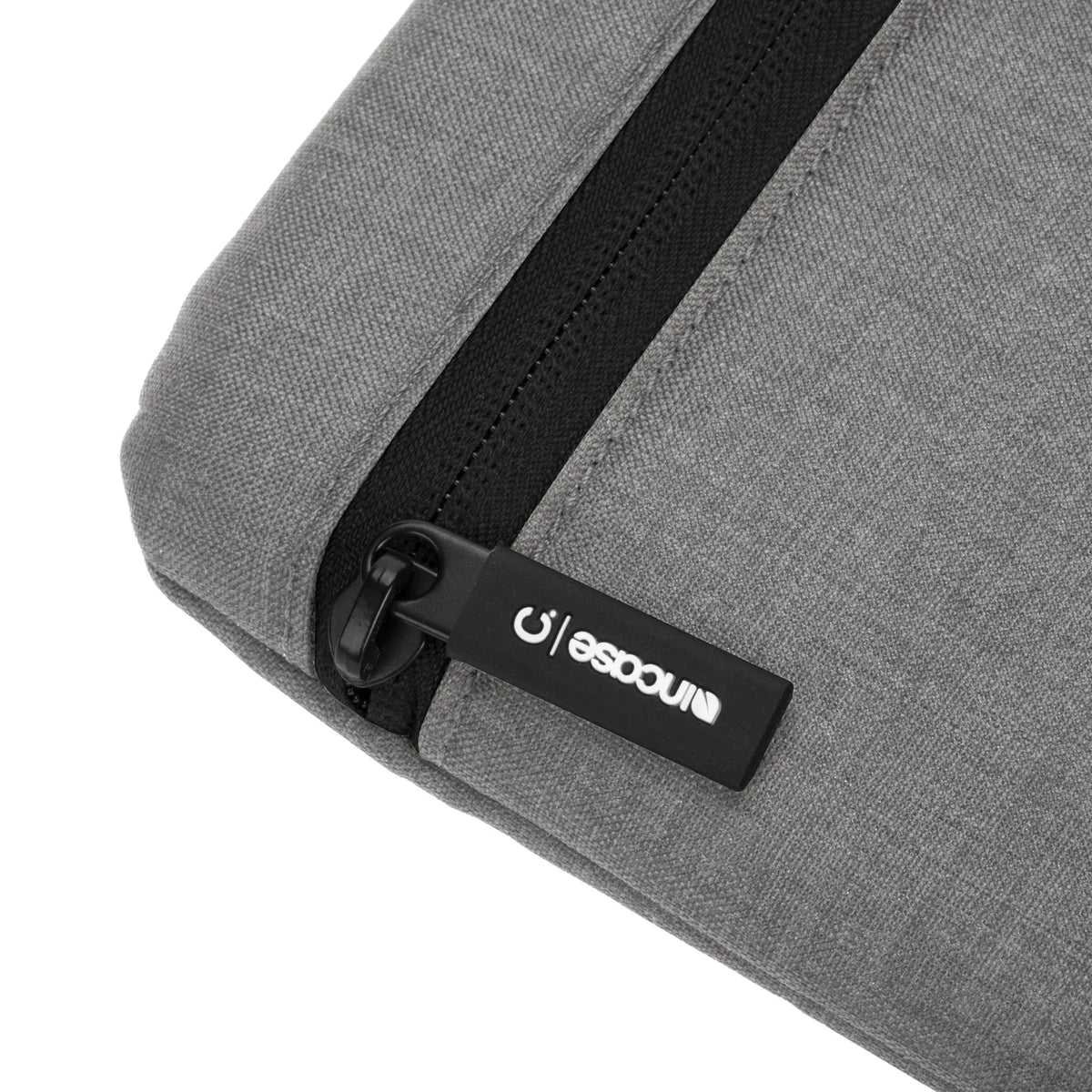 Incase Carry Zip Sleeve for 13-inch laptops in Cement Gray, close-up of the zip pull with its Incase tab on the heathered grey fabric