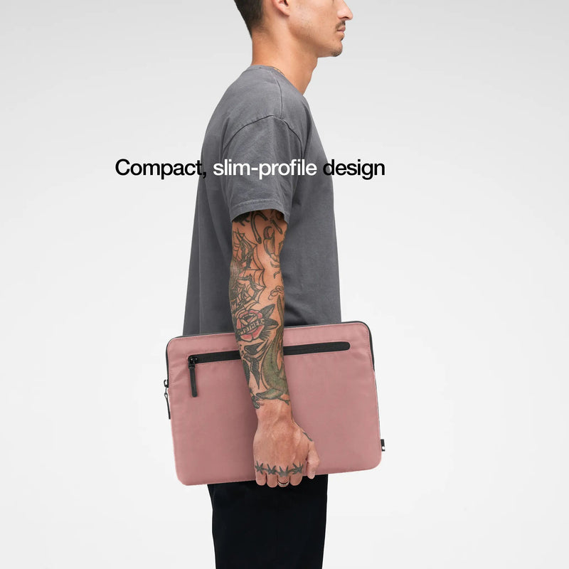 Aged Pink Compact Sleeve carried under the arm by a model, with the caption Compact, slim-profile design