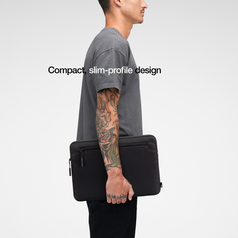 Black Compact Sleeve carried under the arm by a model, with the caption Compact, slim-profile design
