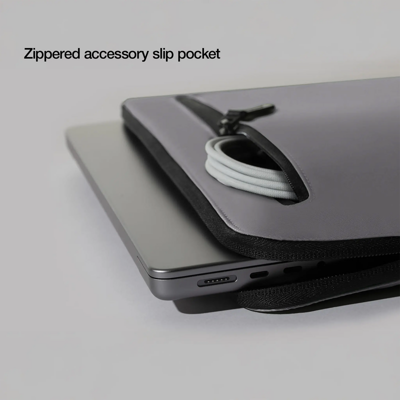 Close-up of the Conte Grey Compact Sleeve front zip pocket holding a cable, with the caption Zippered accessory slip pocket