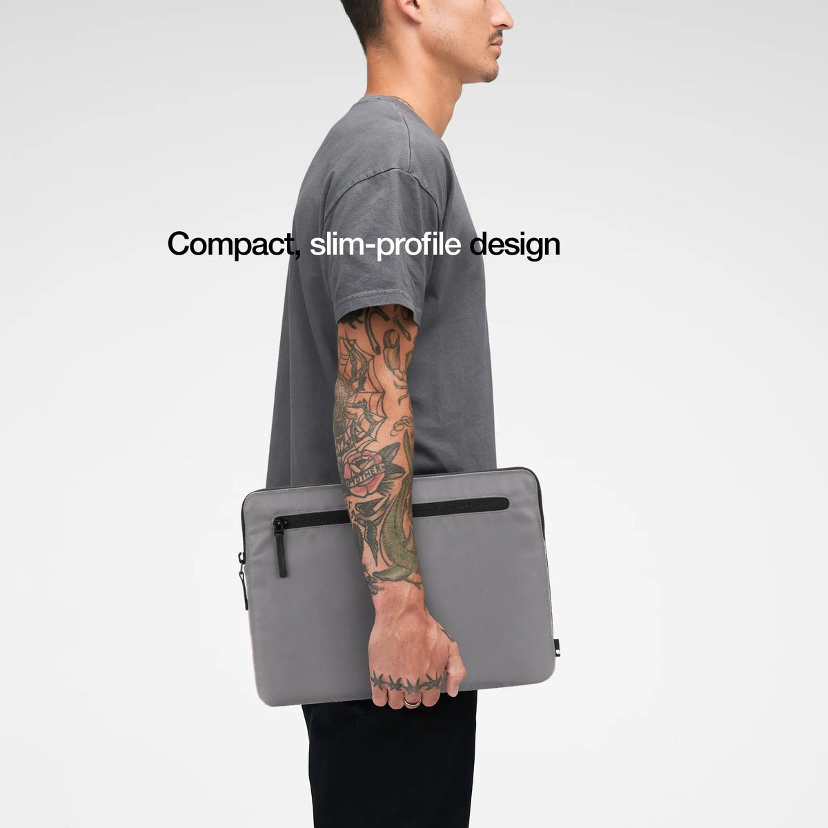 Conte Grey Compact Sleeve carried under the arm by a model, with the caption Compact, slim-profile design