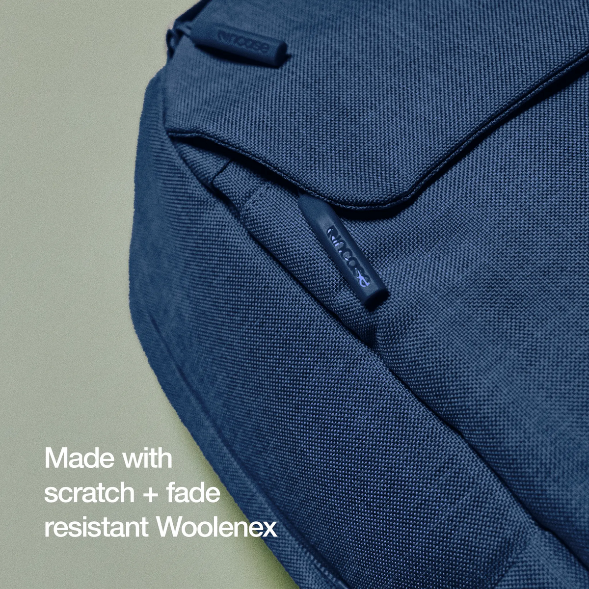 Close-up of the navy Woolenex fabric on the Crosstown Backpack, with the caption Made with scratch and fade resistant Woolenex
