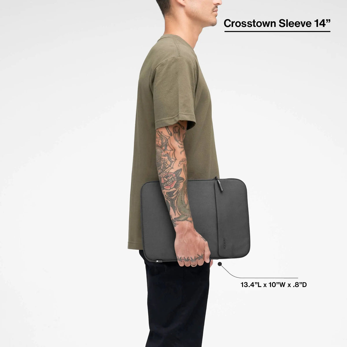 Black Crosstown 14-inch sleeve carried by a model, with the product name and dimensions printed over the image