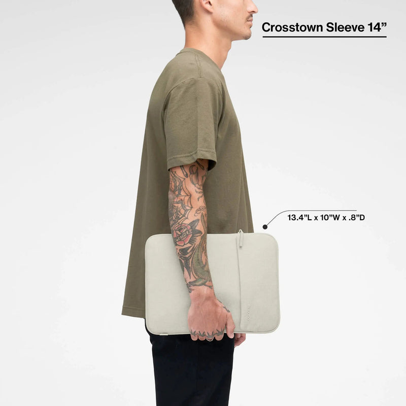 Limestone Crosstown 14-inch sleeve carried by a model, with the product name and dimensions printed over the image