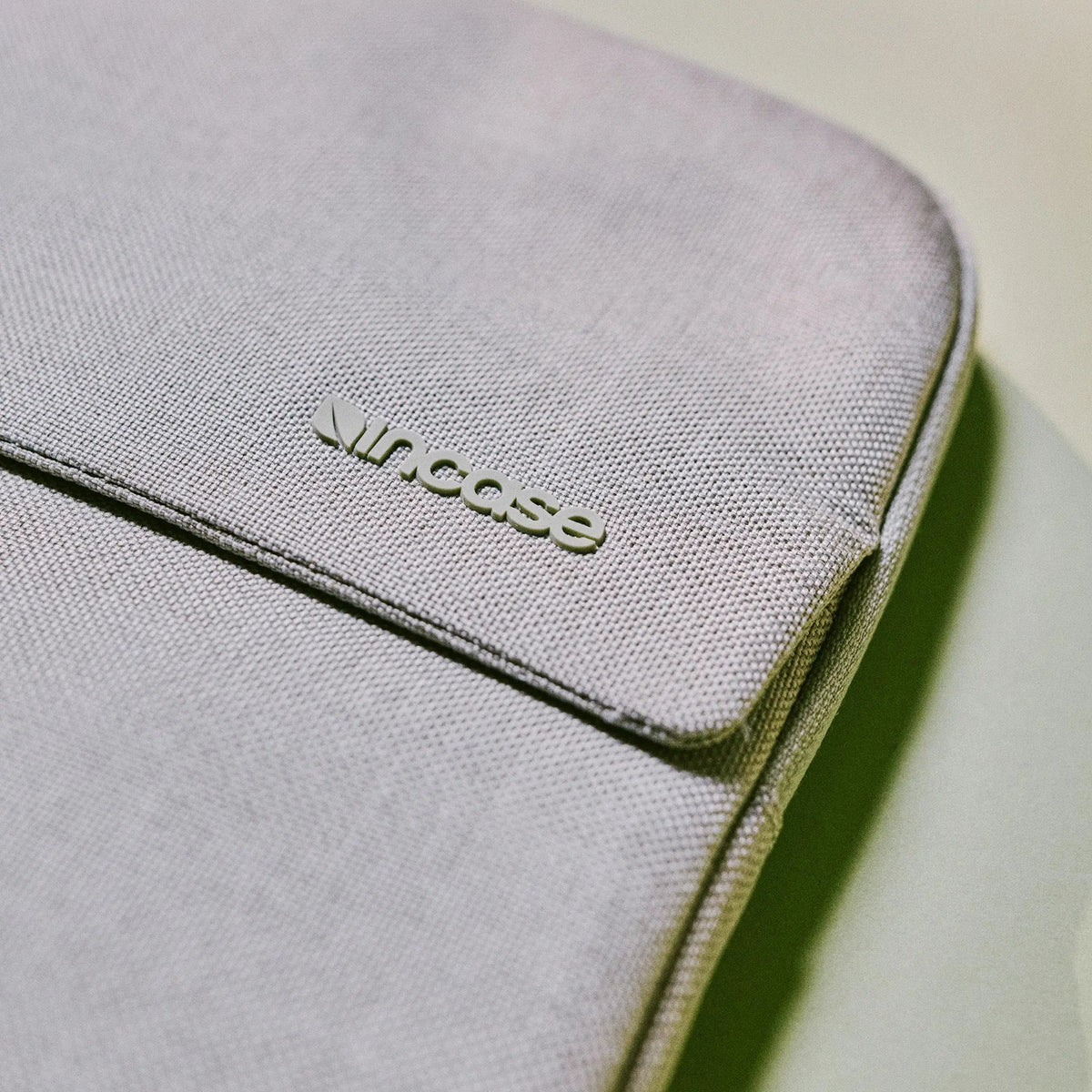 Close-up of the Limestone Woolenex fabric on the Crosstown Sleeve with the embossed Incase logo