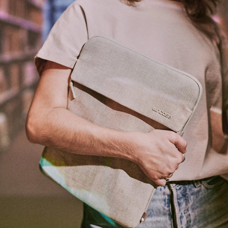 Person holding the Limestone Crosstown Sleeve against their body in a library setting