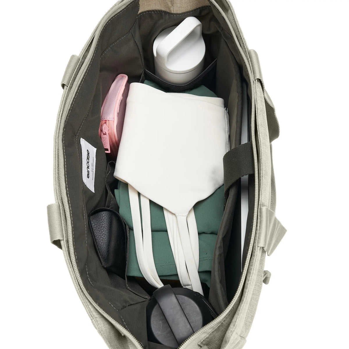 Top-down view into the open Limestone Crosstown Tote showing the contents and internal pockets