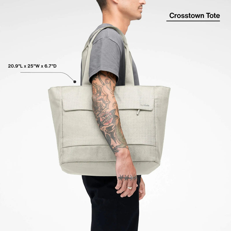 Limestone Crosstown Tote carried on a model's shoulder, with the product name and dimensions printed over the image
