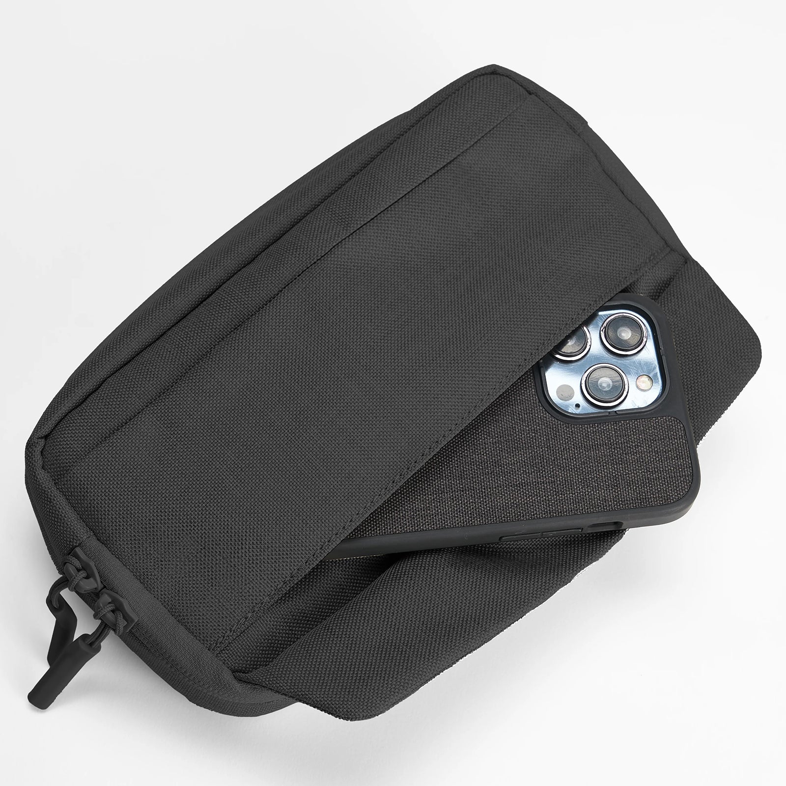 Close up of the quick access front pocket partially holding a smartphone. The image demonstrates fast access while maintaining secure storage for frequently used devices.