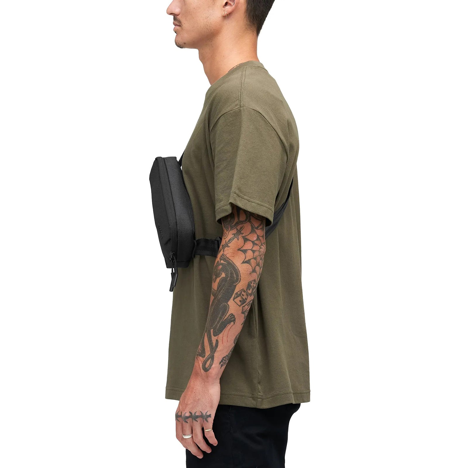 Side profile of the Incase Crosstown Sling Black worn by a model. The slim depth and ergonomic fit show how comfortably the bag sits close to the body during everyday movement.