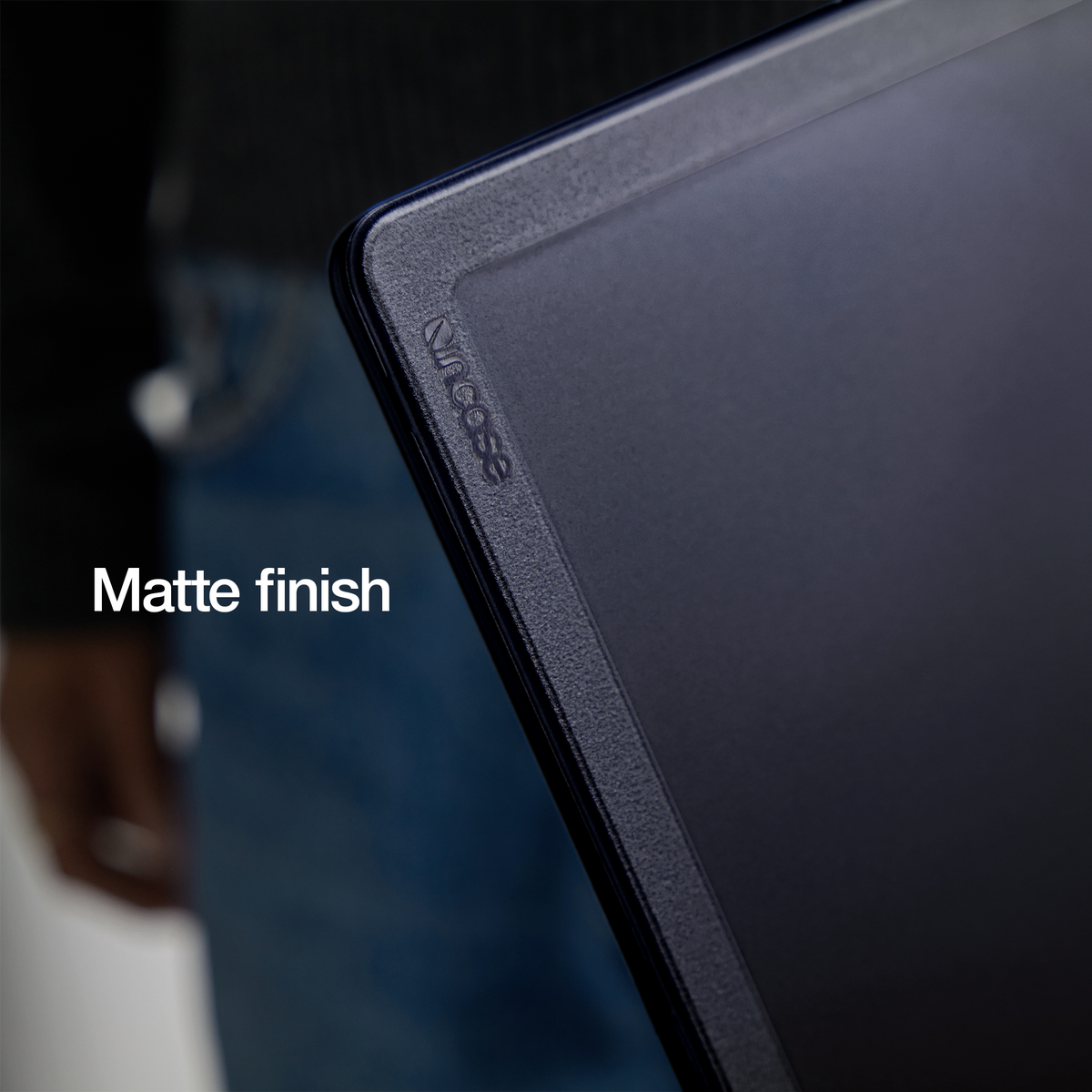 Close-up of a corner of the Black Edge Hardshell fitted to a dark blue MacBook Air, which shows through the tinted shell and gives it a navy look, with the overlay text Matte finish