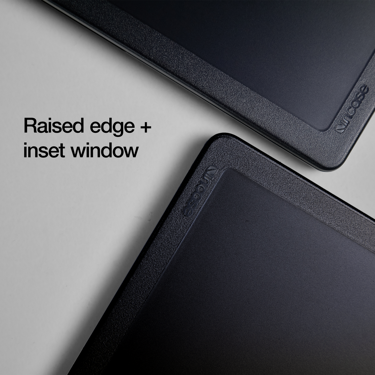 Two corners of the Black Edge Hardshell overlapping to show the raised edge and inset window, with overlay text