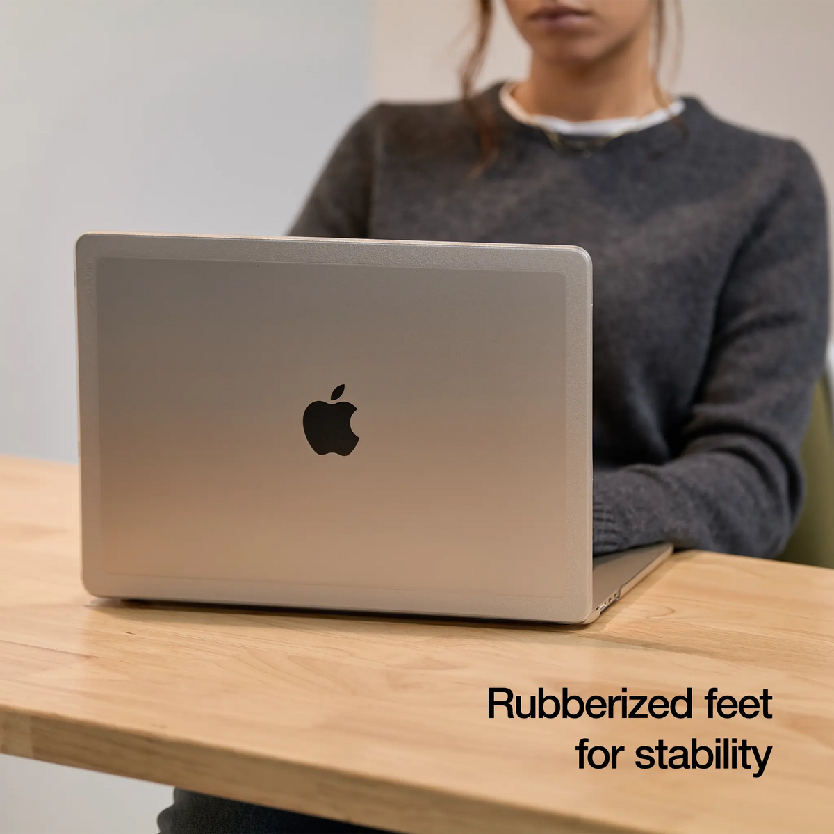 MacBook Air in the Clear Edge Hardshell open on a wooden desk, with the overlay text Rubberized feet for stability