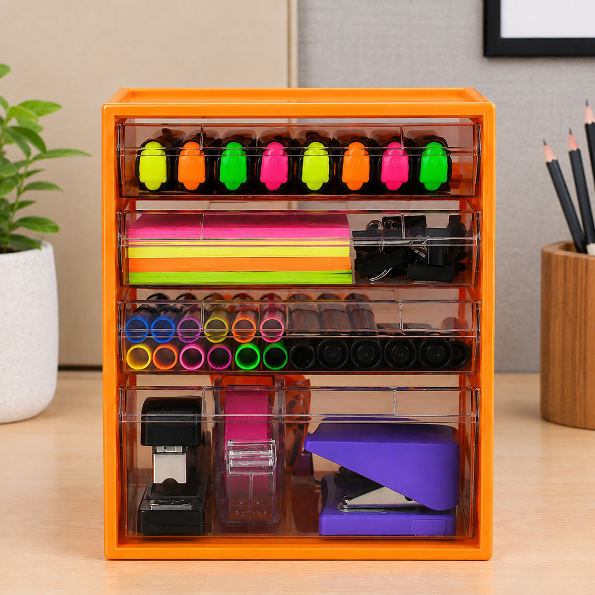 Front view of the Italplast Mandarin 4 Drawer Office Organiser displaying its three smaller upper drawers and spacious lower drawer. The clear compartments neatly separate highlighters, sticky notes, binder clips, coloured pens, staplers and tape, demonstrating organised desktop storage for a busy office, classroom or study area.